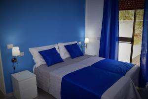 a blue bedroom with a bed with blue walls at Il Rifugio d'aMare in Agropoli