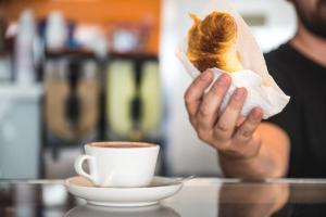 トル・ヴェルガータにあるCX Rome Student Placeの菓子・コーヒーを持つ者