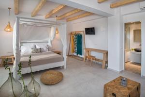 a bedroom with a bed and a chair at Casa Vitae Suites in Kamari