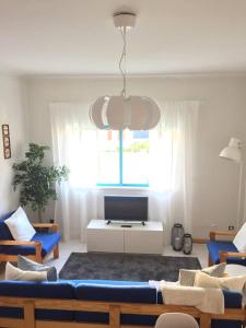 un soggiorno con divano blu e TV di Lovely and Cozy Quiaios 1 Bed Apartment a Palheiros de Quiaios