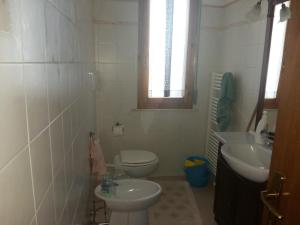 a white bathroom with a toilet and a sink at WONDERVIEW GALIMBERTI 18 in Montepulciano