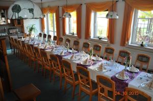 a long dining room with a long table and chairs at Turmhotel Schwedt in Schwedt