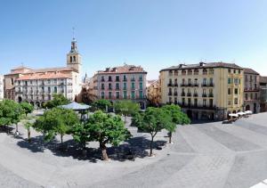 a group of buildings and trees in a courtyard at Hotel Infanta Isabel by Recordis Hotels in Segovia