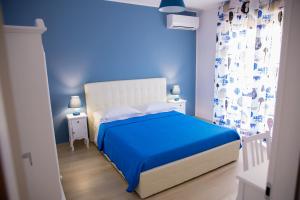 a blue bedroom with a bed and blue walls at Gleda Rooms in Pompei