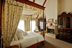 ein Schlafzimmer mit einem Himmelbett und einem Kamin in der Unterkunft Hotel Les Mars in Healdsburg