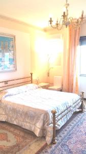 1 dormitorio con 1 cama grande y lámpara de araña en B&B Altura, en Prossedi