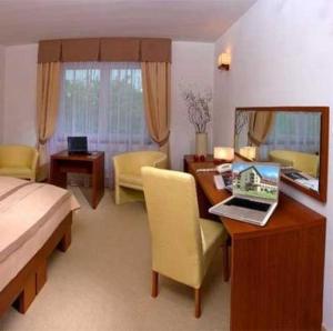 a bedroom with a desk with a laptop computer on it at Ośrodek Wypoczynkowy Ariston in Miłków