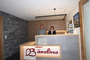a man and a woman standing behind a counter at Hotel Bärolina in Serfaus