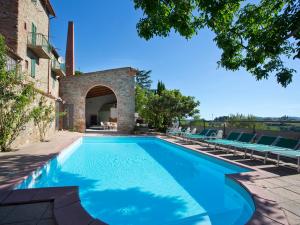 a swimming pool with chairs and a building at Ca' De' Principi - Residenza D'epoca in Piegaro