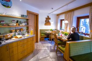 a person sitting at a table in a restaurant at Landhaus Taurer in Kals am Großglockner