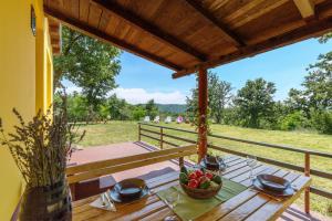 una mesa de madera con un bol de fruta en el porche en Vacation home Latini, en Hum