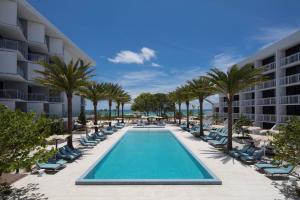 an image of a resort pool with chairs and palm trees at Zota Beach Resort in Longboat Key