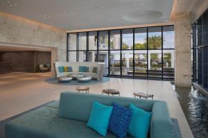 a living room with a blue couch and large windows at Zota Beach Resort in Longboat Key