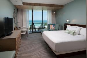 a bedroom with a bed and a living room with a television at Zota Beach Resort in Longboat Key