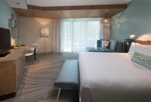 a hotel room with a bed and a desk and a couch at Zota Beach Resort in Longboat Key