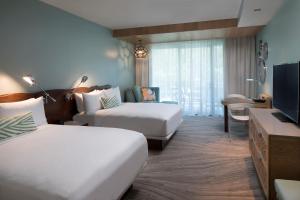 a hotel room with two beds and a television at Zota Beach Resort in Longboat Key