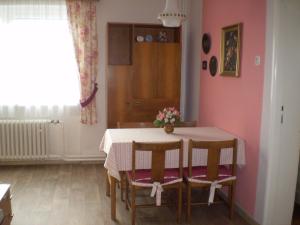 a dining room with a table and some flowers on it at apartman pro 4 osoby in Česká Skalice