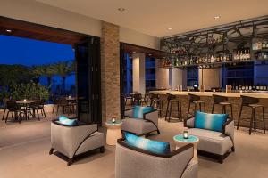 a restaurant with a bar with chairs and tables at Zota Beach Resort in Longboat Key