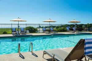 a swimming pool with chairs and umbrellas at The Vista in Gloucester