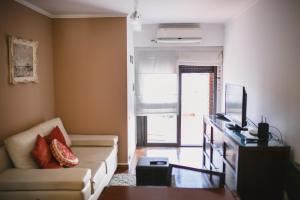 een woonkamer met een bank en een televisie bij 4 PERSONAS A 150 Mts SANATORIO ALLENDE in Cordoba