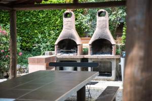 an outdoor pizza oven with a table and a table sidx sidx sidx at Camping le Mas Fleuri in Sospel