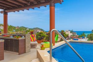 an outdoor swimming pool with a view of the ocean at Beach Break Suites Sayulita in Sayulita