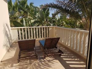 two chairs and a table on a balcony with palm trees at Villa Galleria in Perivolia