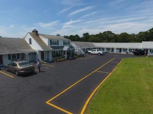 a woman standing in a parking lot next to a building at Knights Inn Centerville Cape Cod Area in Centerville