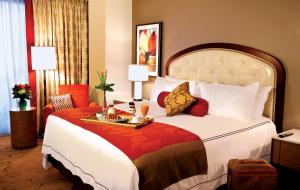 a hotel room with a bed with a tray of food on it at L'Auberge Baton Rouge in Baton Rouge