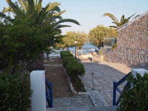 a pathway leading to a beach with trees and a building at Villa Dolphin in Azolimnos Syros