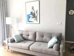 salon z kanapą i zdjęciem na ścianie w obiekcie Apartament Słoneczny Dwie Sosny w mieście Ustronie Morskie