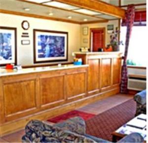 a living room with wooden cabinets and a tv at Winnemucca Holiday Motel in Winnemucca