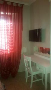 a room with a desk and a red curtain and a chair at Il Rifugio di Dante in Sinalunga