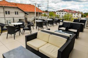 a balcony with a couch and tables and chairs at Konak Zivojinovic in Valjevo