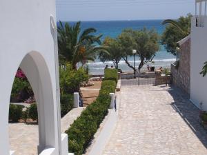a pathway leading to the beach with the ocean in the background at Villa Dolphin in Azolimnos Syros