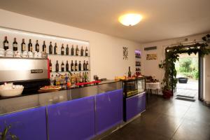 un bar avec des armoires bleues et des bouteilles sur le mur dans l'établissement Hotel Il Monte, à Monte San Savino