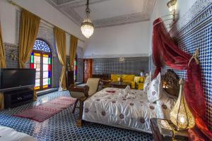 um quarto com uma cama e uma televisão em Riad Damia Suite &Spa em Fez