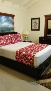 een slaapkamer met een groot bed met rode kussens bij Relax Villa in Ocho Rios
