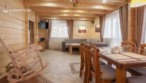 salon ze stołem jadalnym i kanapą w obiekcie Chalet Hutsulyandiya w mieście Mikuliczyn