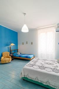 1 dormitorio con paredes azules, 1 cama y 1 silla en Casa Lego Napoli, en Nápoles