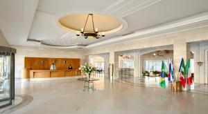 a large lobby with flags in a building at Golden Crown Hotel in Nazareth