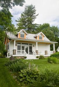 a white house with a porch and lawn at Sugar Hill Inn in Sugar Hill