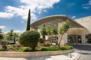 a building with palm trees in front of it at Golden Crown Hotel in Nazareth