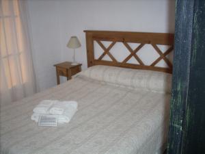 1 dormitorio con 1 cama con toallas en Estilo de Vida en Capilla del Monte