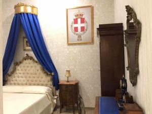 ナポリにあるRoyal Gismondaのベッドルーム1室(青いカーテンと鏡付きのベッド1台付)