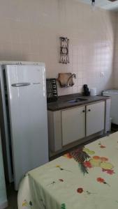 Il comprend une cuisine équipée d'un réfrigérateur blanc et d'un comptoir. dans l'établissement Casa Próxima à Praia Da Cocanha, à Caraguatatuba