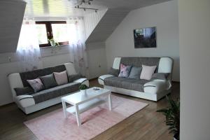 a living room with two couches and a table at Lake House Apartment in Medvode