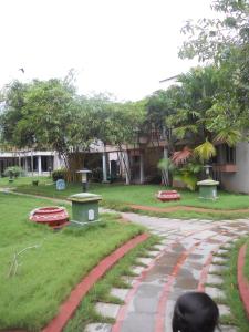 een loopbrug voor een tuin met een gebouw bij Hotel Sadhabishegam in Vaithīsvarankoil