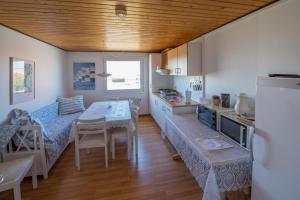 a kitchen with a table and a dining room at Annekset Vesterø Havn in Læsø