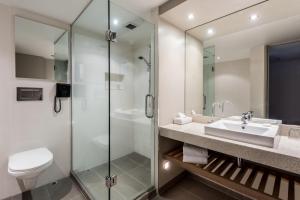 a bathroom with a sink and a glass shower at Waipuna Hotel & Conference Centre in Auckland